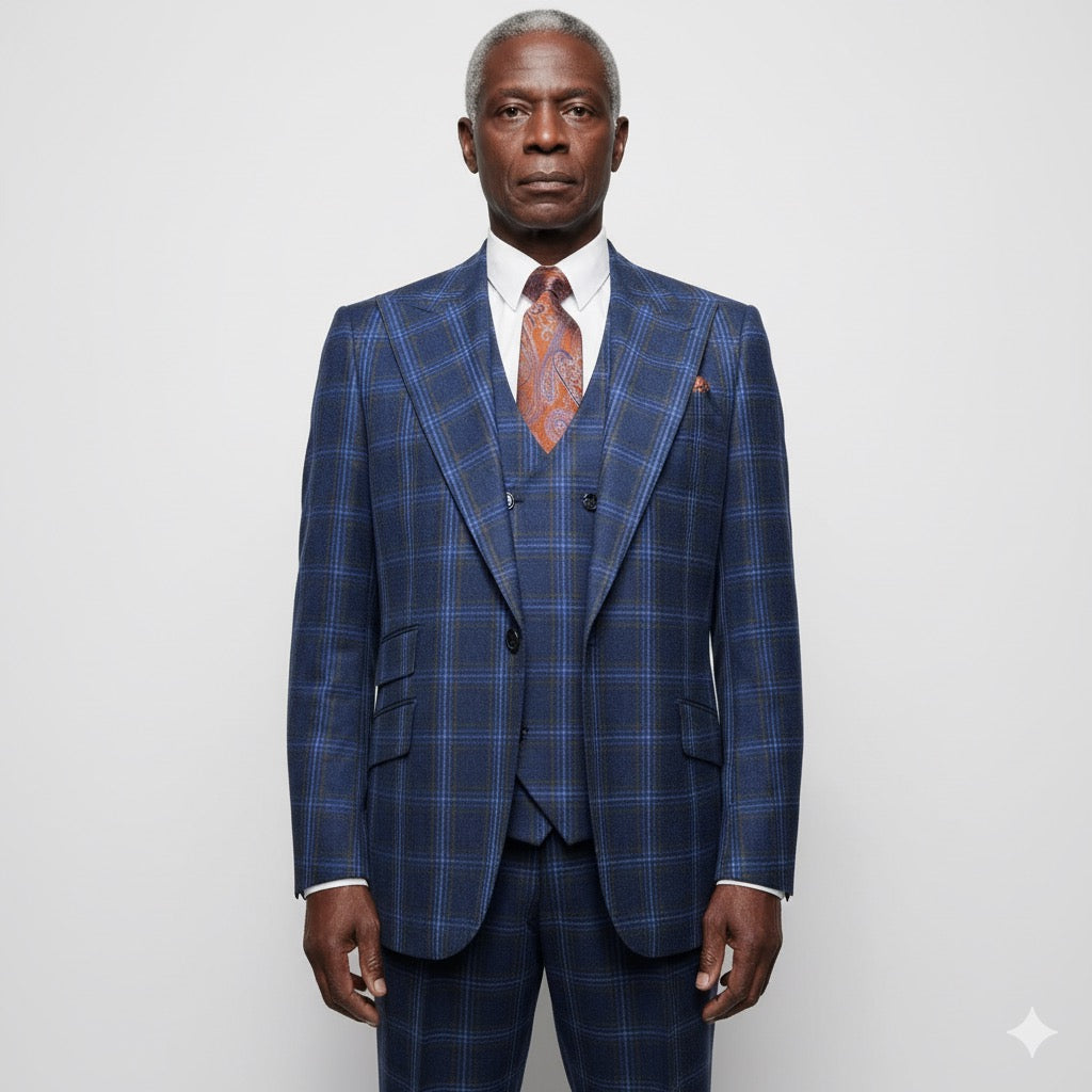 The mannequin displays a striking Tiglio Rosso Orvietto Blue/Rust Windowpane suit (sizes 50R and 52R), made from 100% wool, with a matching waistcoat and an orange tie beautifully contrasting the dark industrial background.