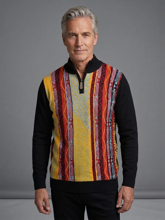 An older man with gray hair is wearing the Suslo Couture Half Zip Sweater FP206 by Unique Design Menswear, featuring a colorful geometric knit design with vertical stripes, while standing in front of a plain gray background.