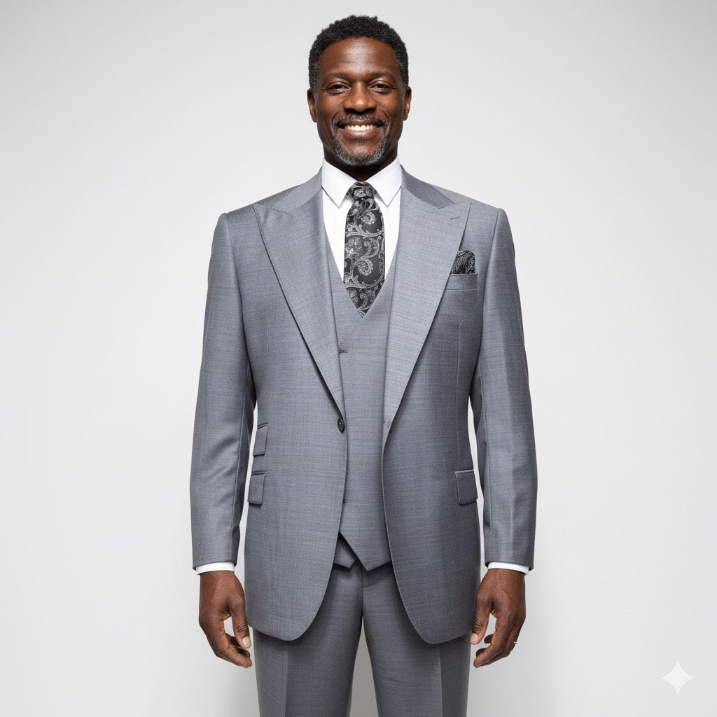 A mannequin elegantly dressed in the Tiglio Rosso Orvietto Solid Grey E09063/26 Single Pleat three-piece suit, crafted from 100% wool and complemented by a patterned tie and pocket square, stands against a neutral textured background that perfectly highlights the sophistication of Tiglio Rosso suits.