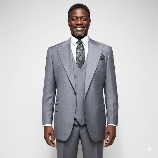 A mannequin elegantly dressed in the Tiglio Rosso Orvietto Solid Grey E09063/26 Single Pleat three-piece suit, crafted from 100% wool and complemented by a patterned tie and pocket square, stands against a neutral textured background that perfectly highlights the sophistication of Tiglio Rosso suits.