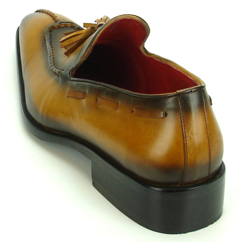 The FI-8701 Tan Encore by Fiesso is a handcrafted men’s leather loafer in brown, with tassels, darker shading on the toe and heel, and a red interior lining.