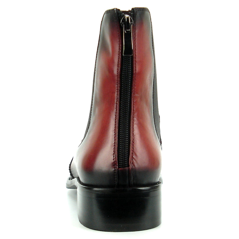 A handcrafted burgundy leather Chelsea boot with black wingtip brogue detailing, elastic side panels, and a low heel—shown on a white background—FI-8708 Wing Tip Boot Encore by Fiesso exemplifies men’s fashion boots from the brand.