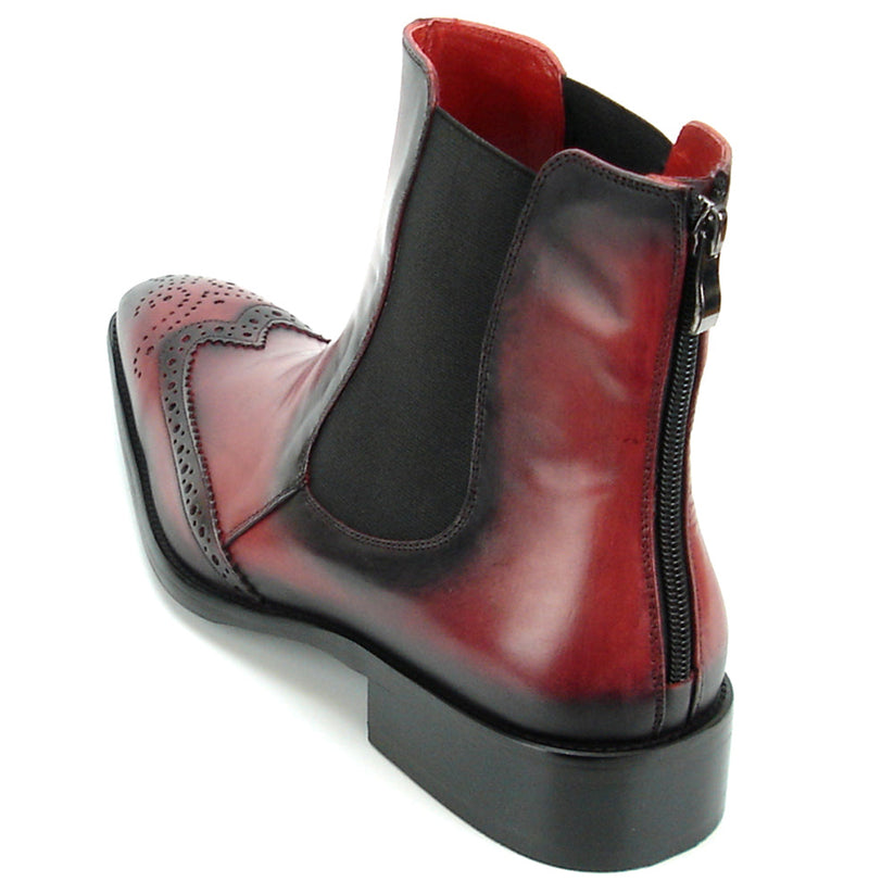 A handcrafted burgundy leather Chelsea boot with black wingtip brogue detailing, elastic side panels, and a low heel—shown on a white background—FI-8708 Wing Tip Boot Encore by Fiesso exemplifies men’s fashion boots from the brand.