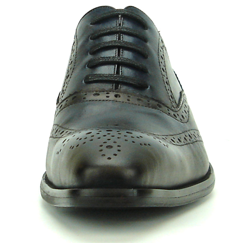 The FI-8710 Black Wing Tip Encore by Fiesso, a men’s fashion shoe in black and navy blue crafted from leather with decorative perforations, black laces, and a low heel, is displayed on a white background.