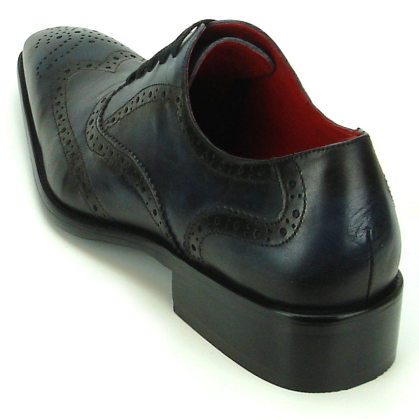 The FI-8710 Black Wing Tip Encore by Fiesso, a men’s fashion shoe in black and navy blue crafted from leather with decorative perforations, black laces, and a low heel, is displayed on a white background.