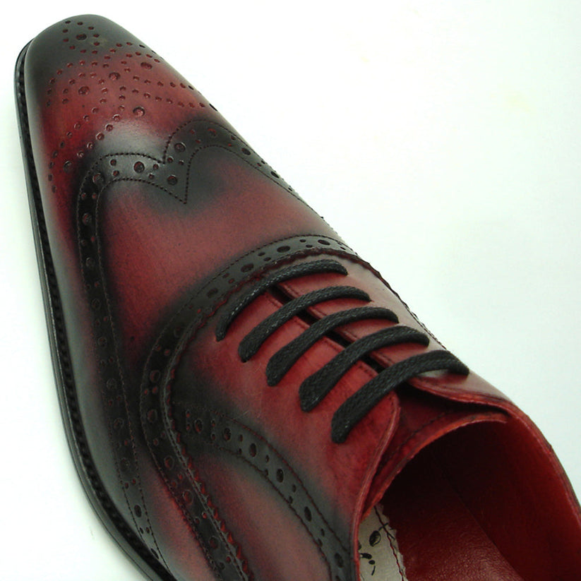 Introducing the FI-8710 Burgundy Wing Tip Encore by Fiesso—a single oxford dress shoe crafted from burgundy and black handcrafted leather, featuring classic brogue detailing, black laces, and a stylish low heel. This exceptional shoe from Fiesso is a standout choice for those seeking distinctive men’s fashion footwear.
