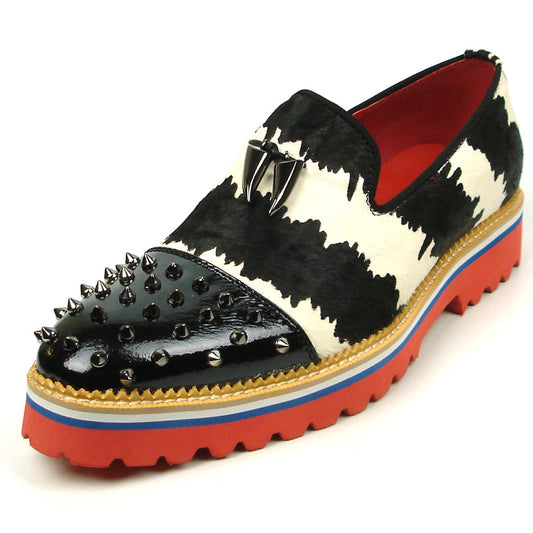 The FI-7455 Black White Cap Toe Spikes Slip On with Tassel by Fiesso features handcrafted leather, a red sole, blue trim, metal studs on the toe, and bold triangular metal accents—perfect for standout men’s fashion.