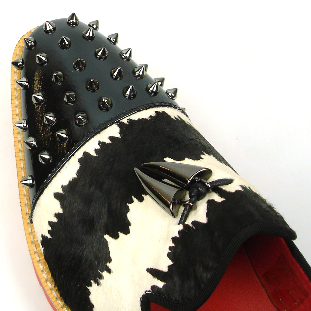The FI-7455 Black White Cap Toe Spikes Slip On with Tassel by Fiesso features handcrafted leather, a red sole, blue trim, metal studs on the toe, and bold triangular metal accents—perfect for standout men’s fashion.