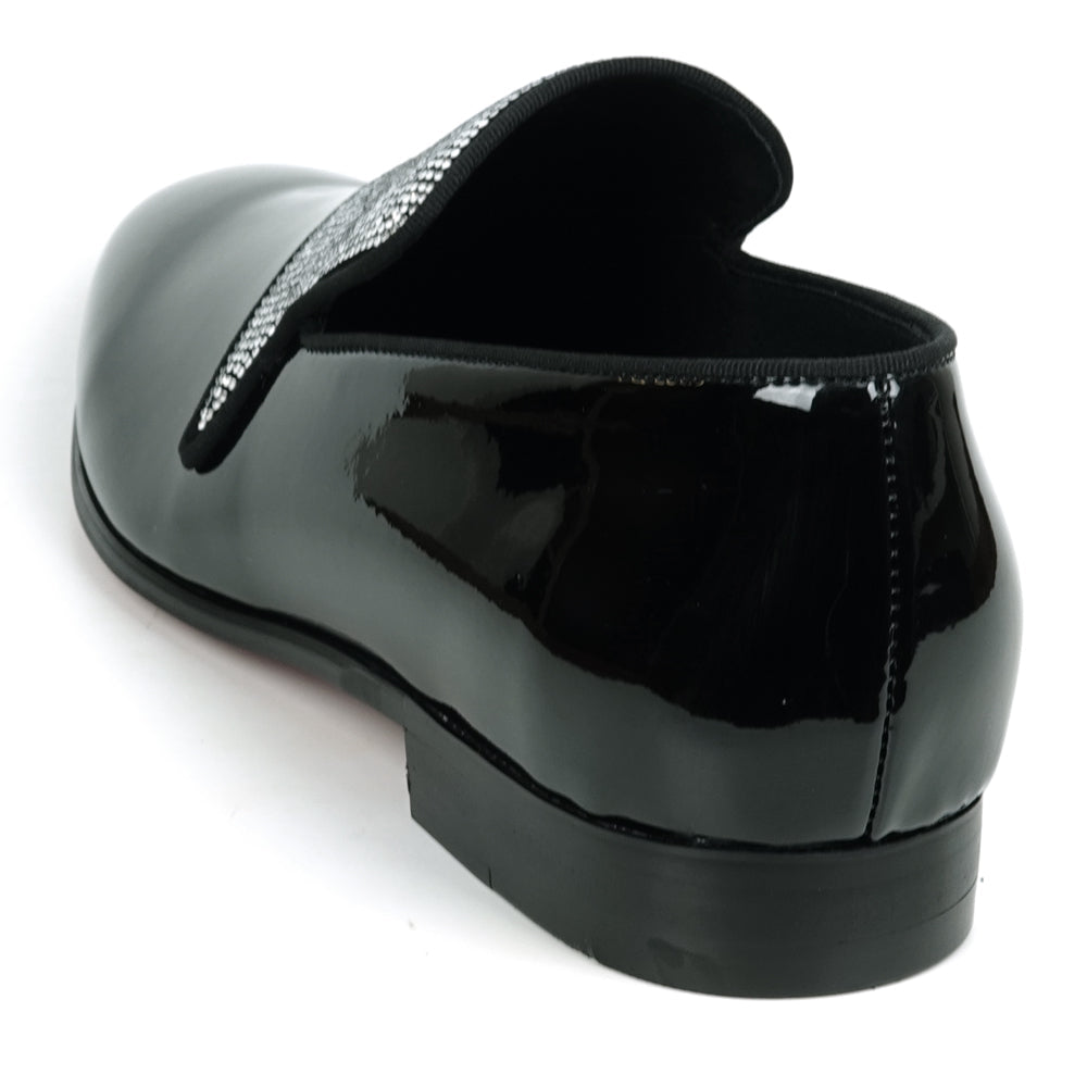The FI-7549 Black Patent Rhinestones Slip on Loafer by Fiesso features a pointed toe and a flap with shiny silver studs, offering a bold update to the classic slip-on style.
