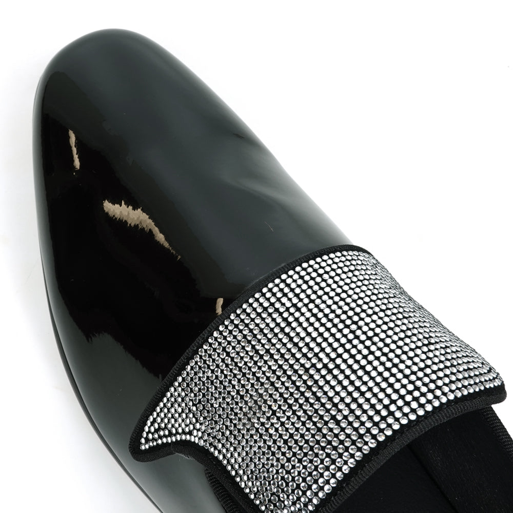 The FI-7549 Black Patent Rhinestones Slip on Loafer by Fiesso features a pointed toe and a flap with shiny silver studs, offering a bold update to the classic slip-on style.