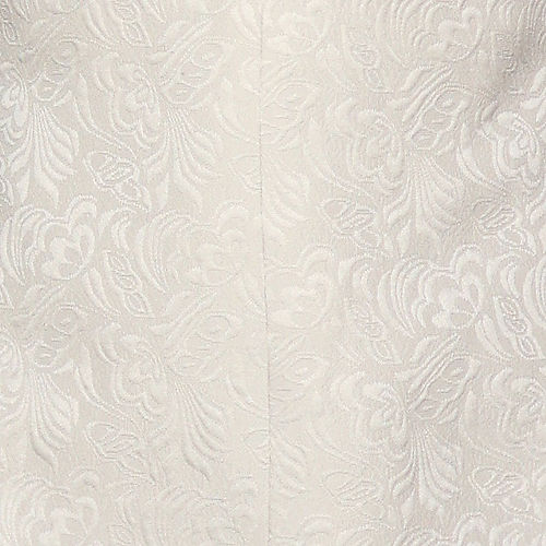 A man in a Manzini Giorgio 3PC slim fit tan tuxedo with a floral pattern, black bead lapel by Insomnia, stands against a textured stone wall, wearing a white shirt and bow tie.