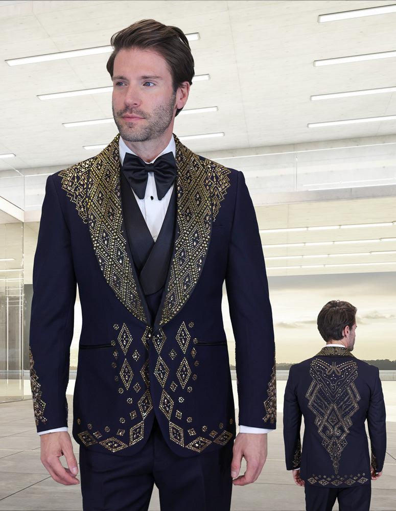 A man wearing the STATEMENT CLOTHING | GIOVANI-B-GOLD navy Italian tuxedo from Statement Clothing—featuring gold geometric embroidery—is seen in a bright, modern room; both his front and back views are shown.