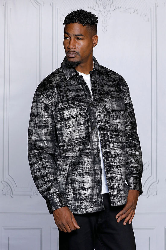 A man models the Insomnia's MANZINI GREECE Silver Metallic Fabric Button Down Coat, gazing to the side against an ornate white wall background.