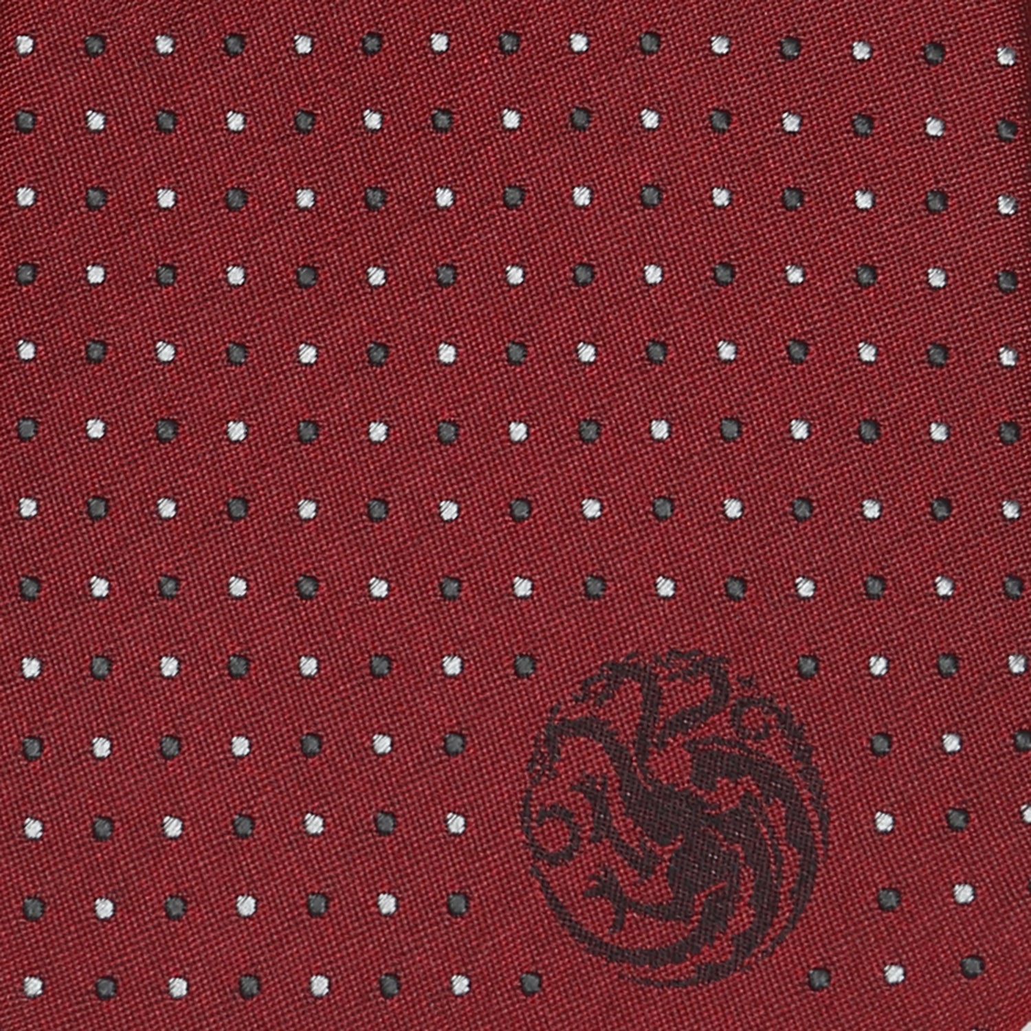 The Game of Thrones Targaryen Dragon Sigil Men's Tie by Cufflinks.com is a rolled-up red tie featuring small white polka dots and a black dragon emblem on the front.