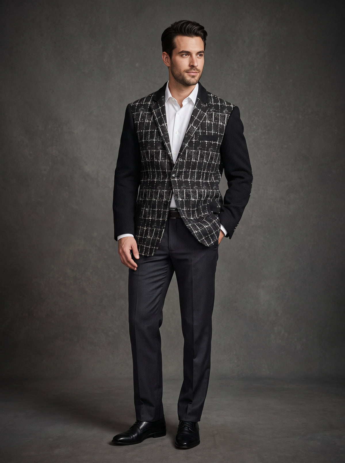 The Inserch Blazer 5062-01 in black, featuring a sleek black and white plaid design and sophisticated black sleeves, is displayed elegantly on a hanger against a light wooden background, emanating timeless charm. Exclusively available in size 3XL as a final sale item from the brand Inserch.