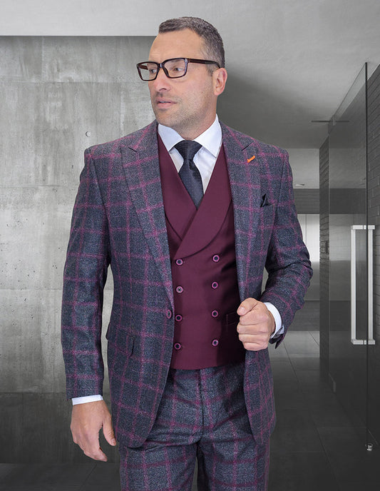 Man wearing the STATEMENT CLOTHING | HARTFORD-BLACK-BURGUNDY suit by Statement Clothing with a maroon double-breasted vest, white shirt, tie, and glasses, standing in a modern interior hallway.
