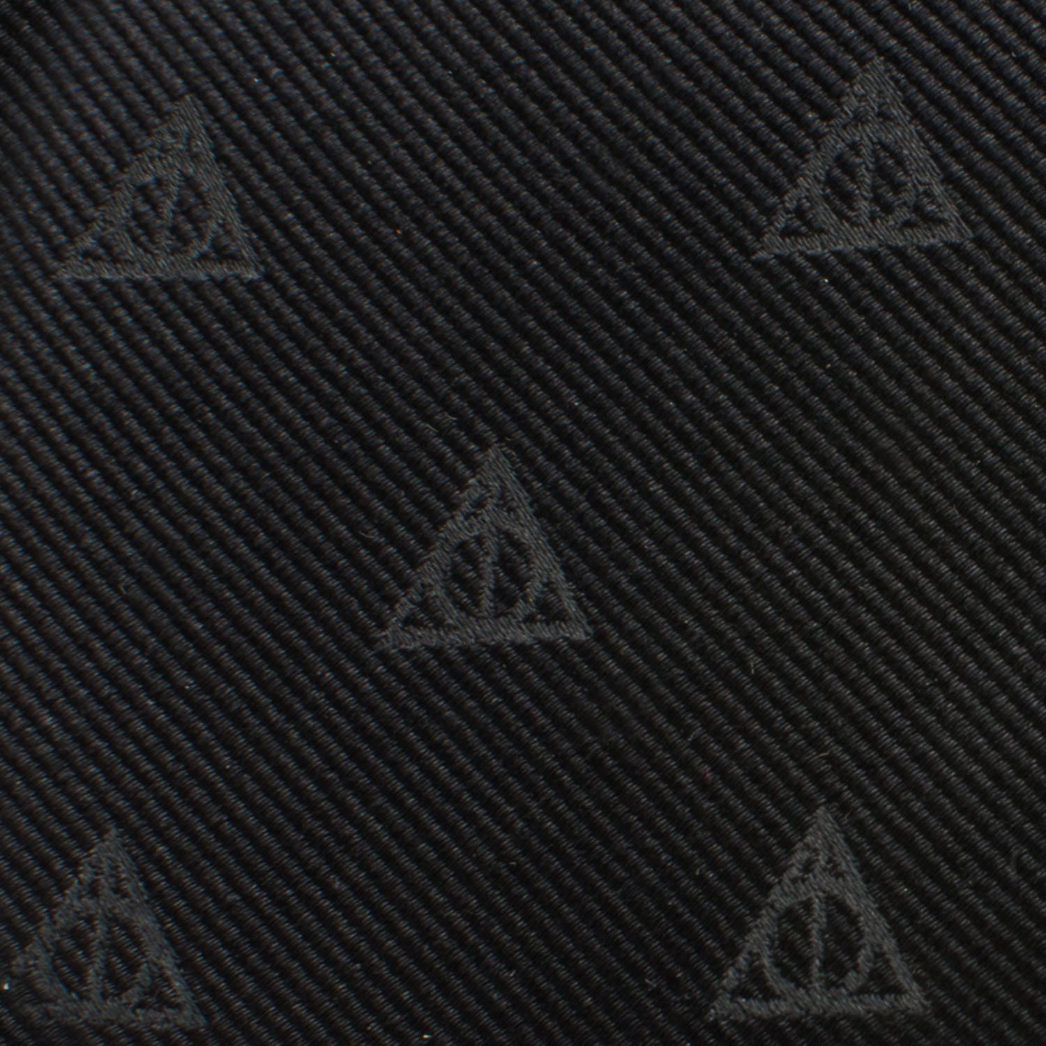 The Harry Potter Deathly Hallows Tie by Cufflinks.com is a black silk tie with a subtle, repeating pattern of small triangle symbols.