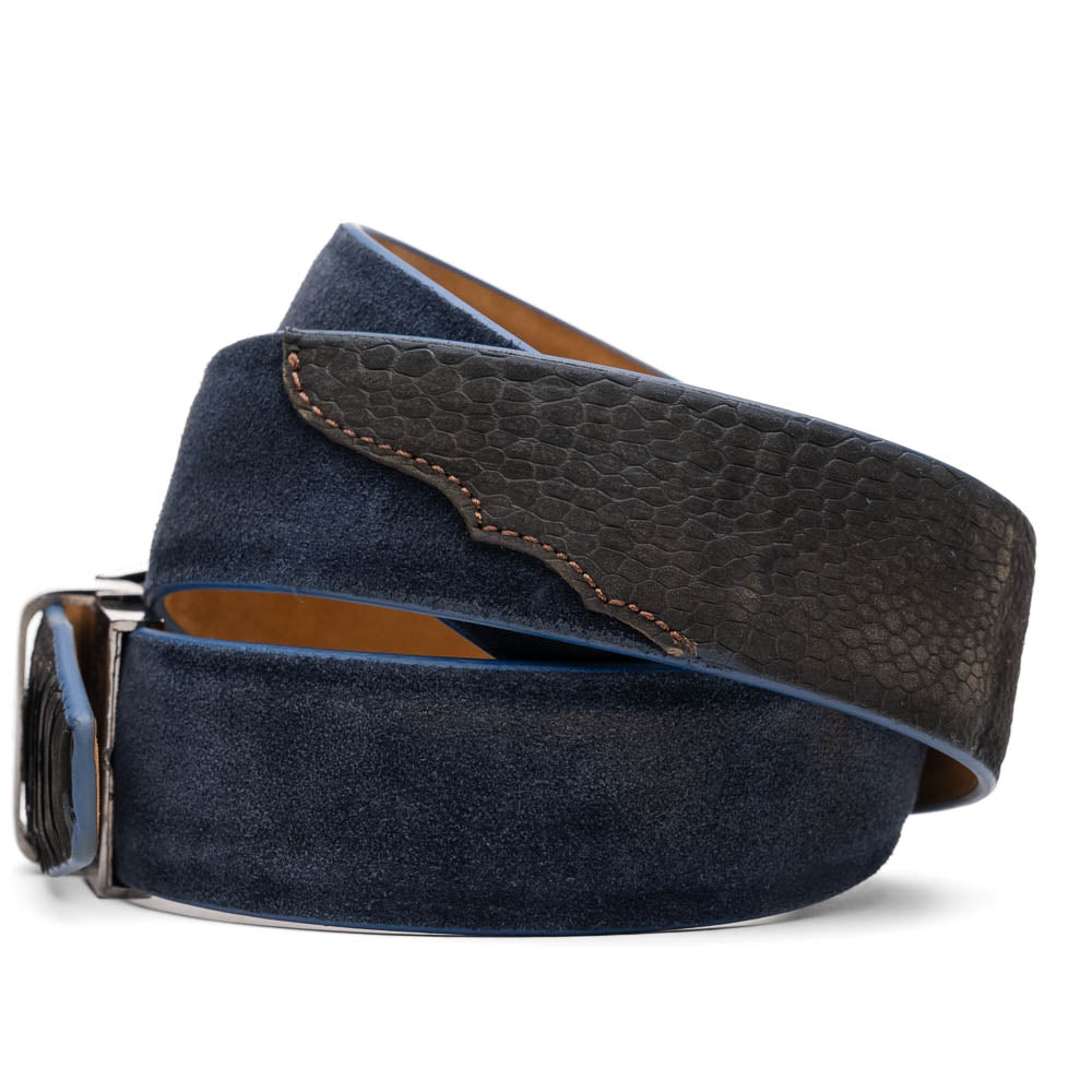 The Hugo Belt Black / Navy by Marco Di Milano, inspired by their signature designs, combines navy suede and black textured leather with a silver logo-engraved buckle, elegantly coiled against a white background.