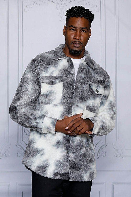 A man wearing an Insomnia MANZINI ICELAND grey soft fleece button sweater shirt stands against a light, decorative background. Made from super soft poly fleece, it requires dry cleaning for optimal care.