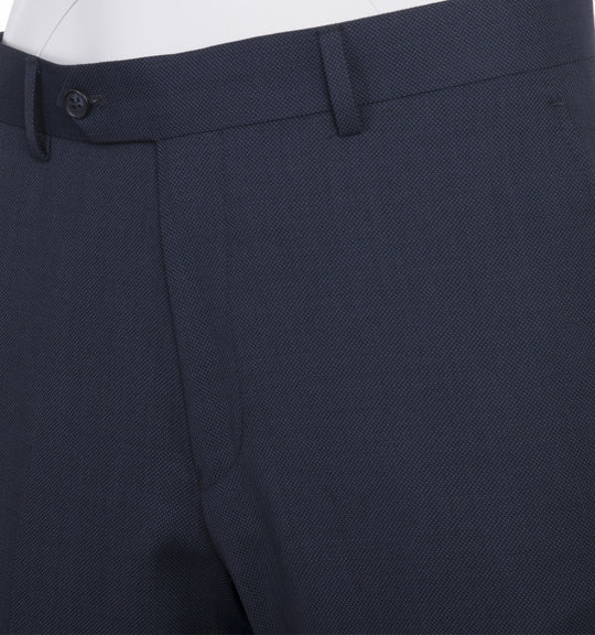 The Tiglio Luxe Novello Blue Birdseye Pure Wool Men’s Suit IDM7018/9 is styled with a white dress shirt and a navy tie with orange polka dots, displayed on a mannequin.