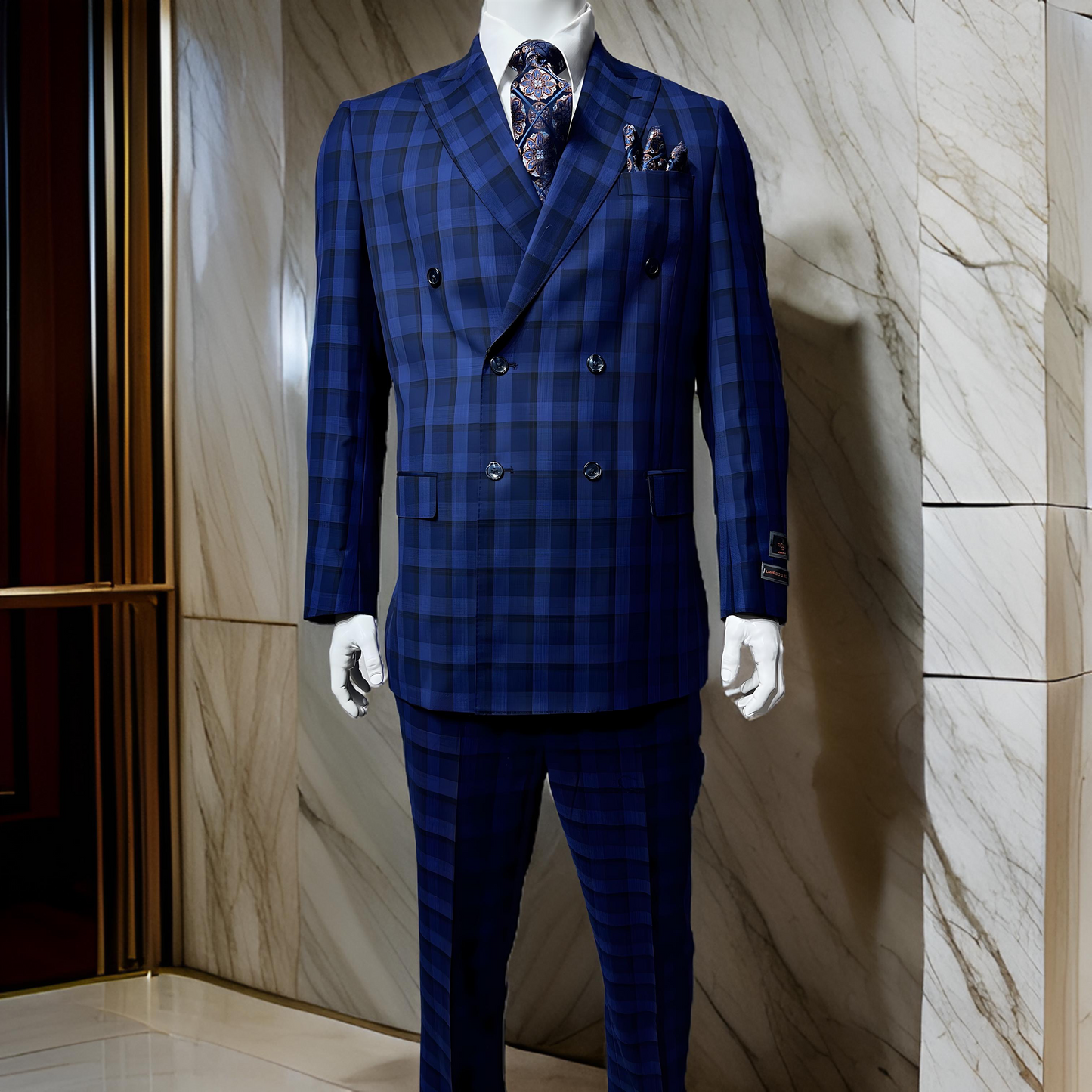 Displayed against a marble wall, the mannequin is dressed in the Tiglio Luxe PISTOIA Double Breasted TL7501 jacket by Tiglio, featuring a modern fit blue plaid design made from Super 150's wool, and complemented by a patterned tie and pocket square.