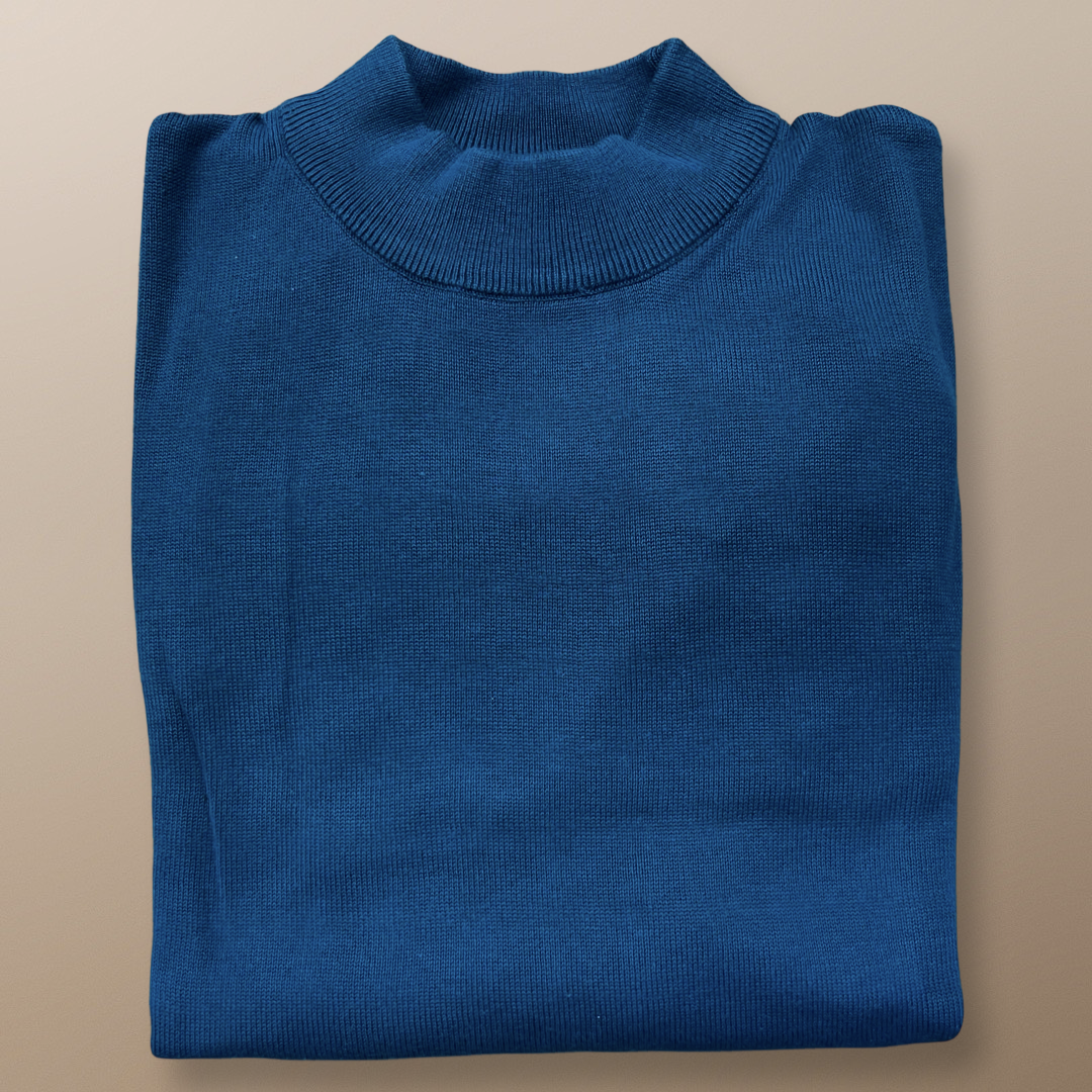 The Inserch Cotton Blend Mock Neck Sweater in True Blue (4308-00101) by Inserch is neatly folded on a beige surface, highlighting its regular fit.