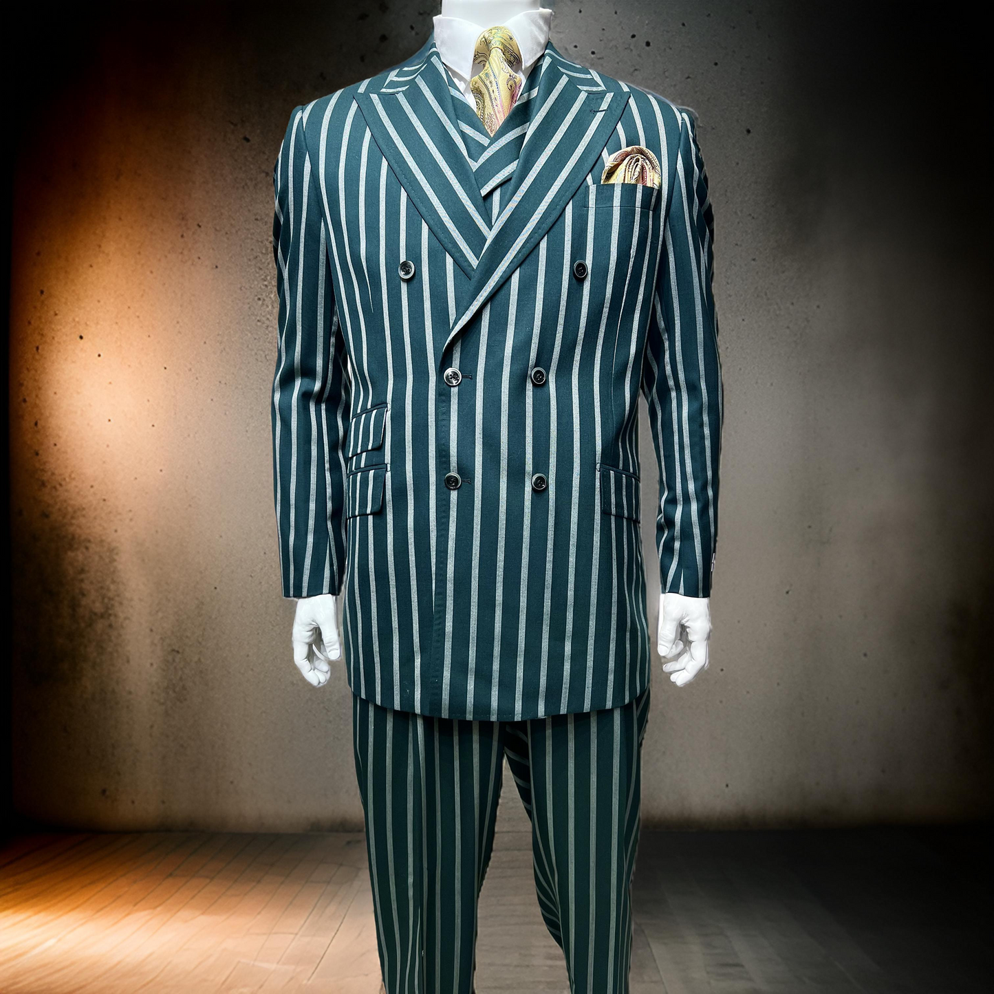 A mannequin wears the Tiglio Rosso DB Este Green Bold Stripe TL4123 suit (40R 52R only) by Tiglio Rosso, featuring bold stripes, a matching vest, white shirt, and patterned tie against a plain, dimly lit background.