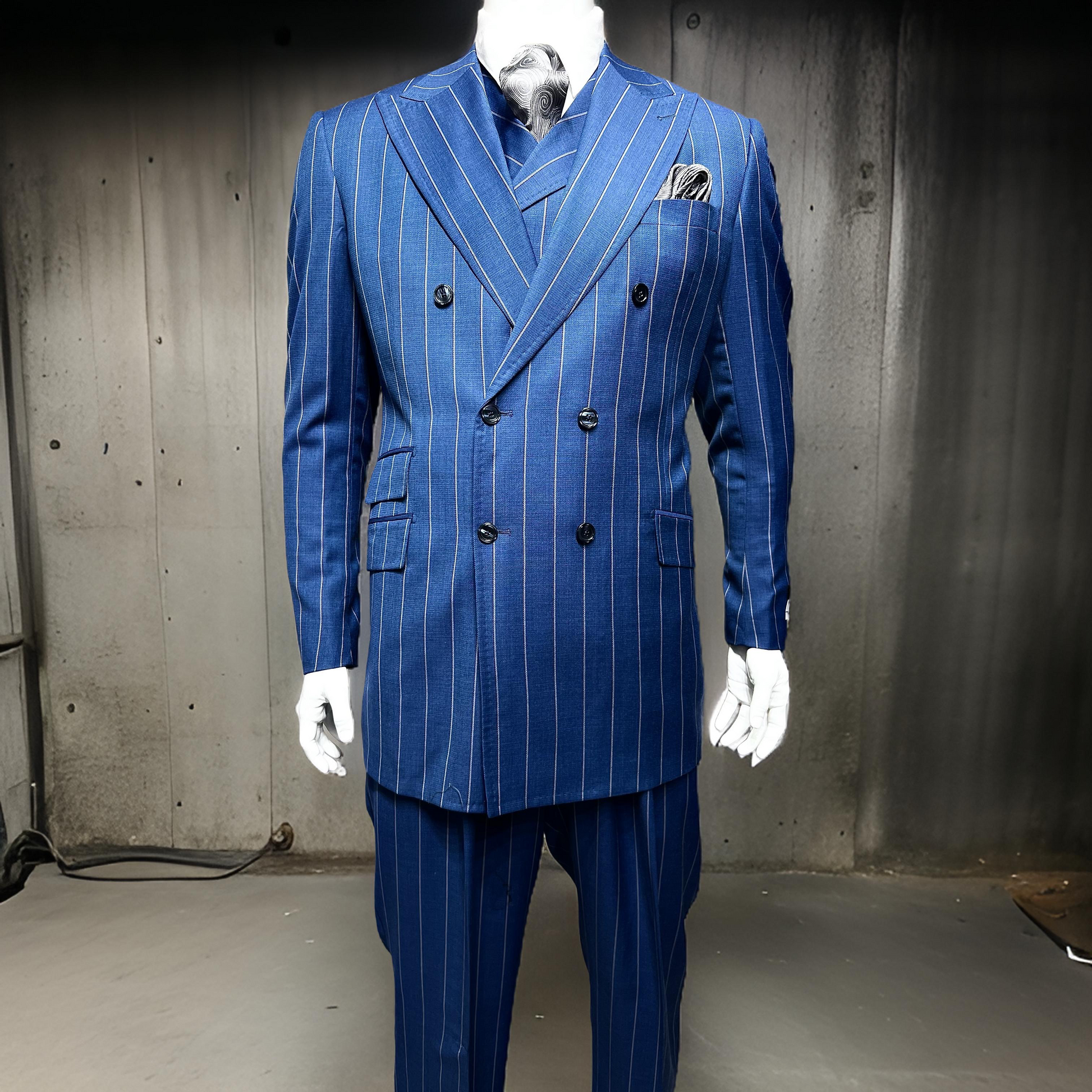 A mannequin displays the Tiglio Rosso DB Este Blue/Grey Pinstripe TL3121 suit (46R 50L ONLY), complete with matching vest and pocket square, showcasing classic wide leg elegance against a minimalist industrial backdrop.