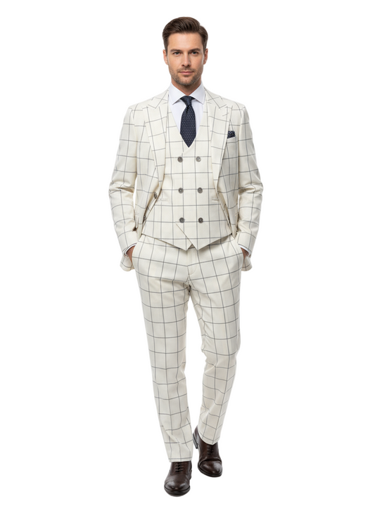 A man exudes confidence in the Tiglio Luxe Off White with Brown Windowpane Prosecco TL4113, a modern fit pure wool suit and vest by Tiglio Luxe. He pairs the suit with a crisp white shirt, a navy blue tie adorned with white dots, and dark brown dress shoes. Standing with hands in his pockets against a white background, he exemplifies the sophistication of Italian menswear.