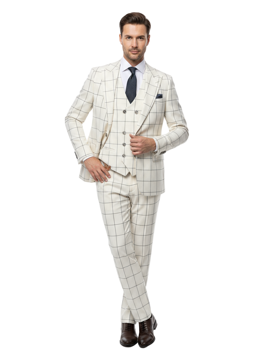 A man exudes confidence in the Tiglio Luxe Off White with Brown Windowpane Prosecco TL4113, a modern fit pure wool suit and vest by Tiglio Luxe. He pairs the suit with a crisp white shirt, a navy blue tie adorned with white dots, and dark brown dress shoes. Standing with hands in his pockets against a white background, he exemplifies the sophistication of Italian menswear.