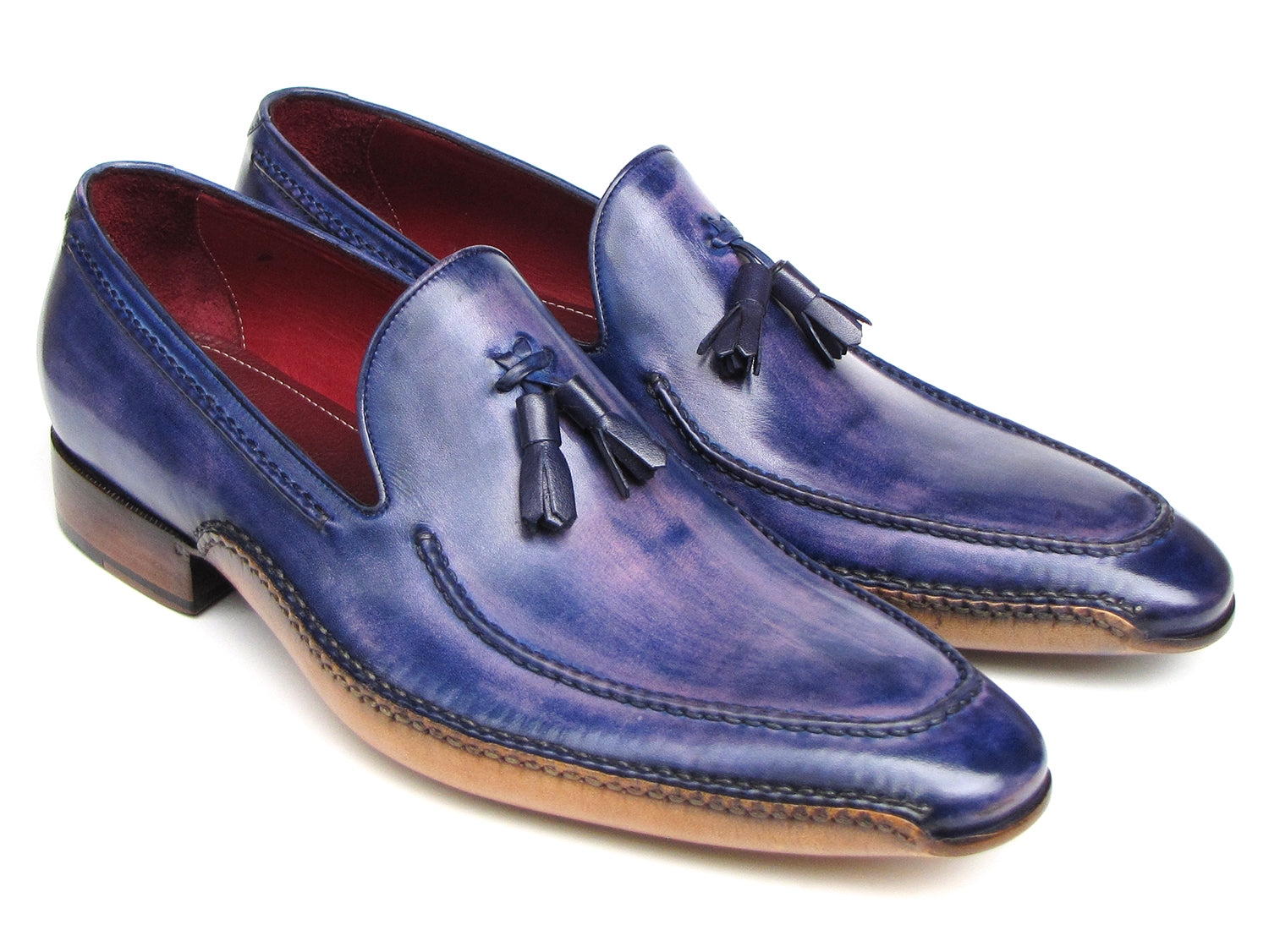 The Paul Parkman Side Handsewn Tassel Loafer Blue & Purple (082-BLU-PURP) pairs hand-painted blue and purple leather with a red interior lining and tan soles, offering stylish slip-on elegance for men.