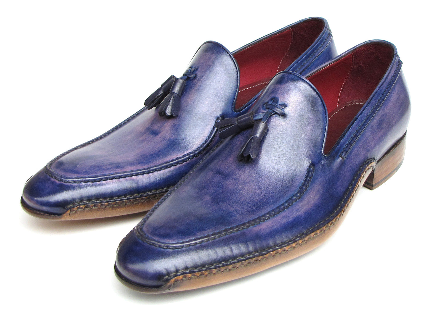 The Paul Parkman Side Handsewn Tassel Loafer Blue & Purple (082-BLU-PURP) pairs hand-painted blue and purple leather with a red interior lining and tan soles, offering stylish slip-on elegance for men.