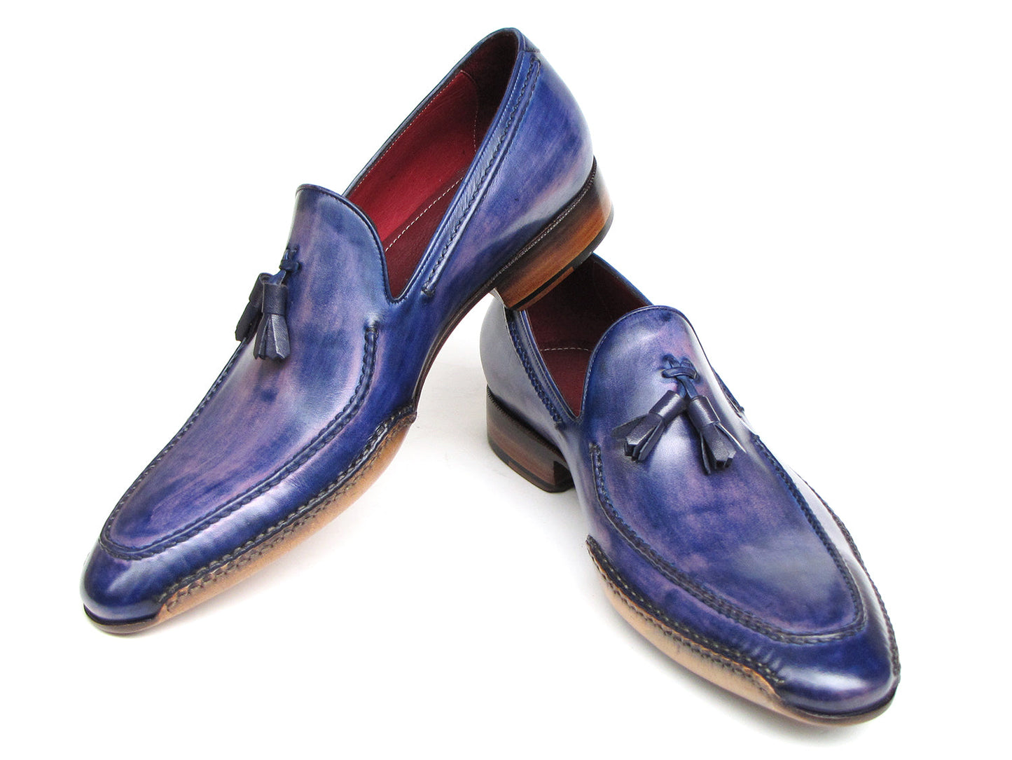 The Paul Parkman Side Handsewn Tassel Loafer Blue & Purple (082-BLU-PURP) pairs hand-painted blue and purple leather with a red interior lining and tan soles, offering stylish slip-on elegance for men.