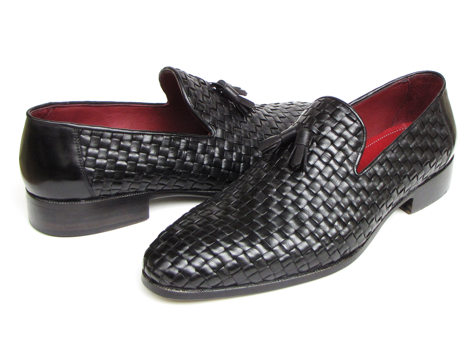 The Paul Parkman Tassel Loafer Black Woven Leather - 085-BLK features black woven leather, red interior lining, and wooden soles—one shoe upright and one on its side to display the elegant men’s footwear from Paul Parkman.