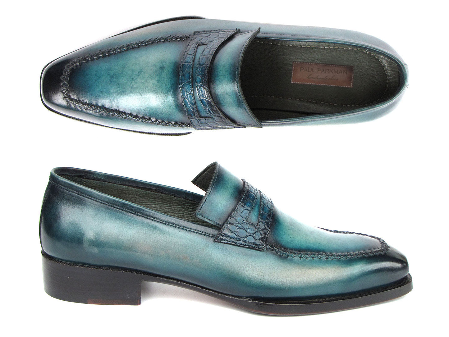 Introducing the Paul Parkman Turquoise Patina Handmade Loafers 6944-TRQ, a stunning pair of teal leather loafers from the renowned brand Paul Parkman. These loafers feature black soles and a stitched design with a decorative strap across the front. Expertly made-to-order, they boast hand-painted leather and Goodyear welted construction for timeless elegance and durability.