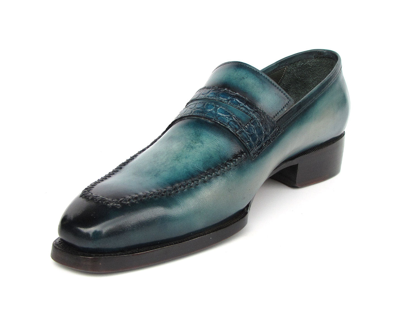 Introducing the Paul Parkman Turquoise Patina Handmade Loafers 6944-TRQ, a stunning pair of teal leather loafers from the renowned brand Paul Parkman. These loafers feature black soles and a stitched design with a decorative strap across the front. Expertly made-to-order, they boast hand-painted leather and Goodyear welted construction for timeless elegance and durability.