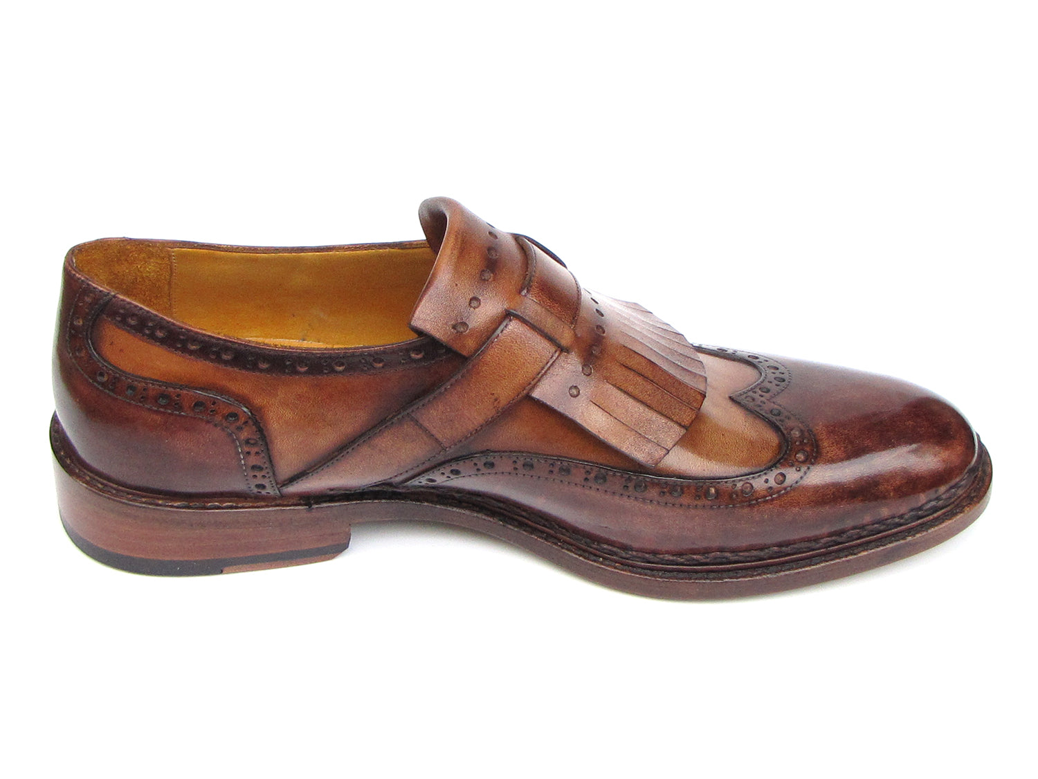 The Paul Parkman Wingtip Monkstraps Brown - 060-BRW features brown leather, decorative perforations, and a fringed kiltie detail. Handcrafted with Goodyear welted construction, this men's dress shoe is shown at a slight angle.