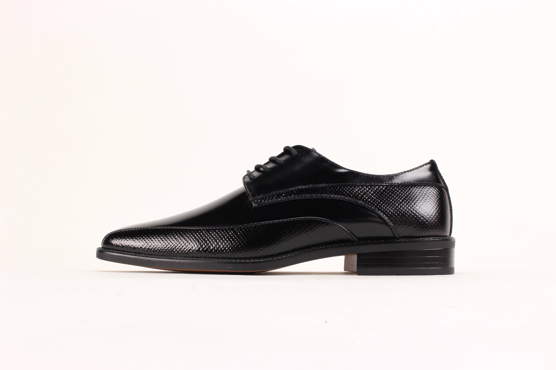 The Giorgio Venturi 7060 Black Leather Shoe features a bike toe, lace-up design, low heel, and embossed textured detailing on the sides and around the sole.