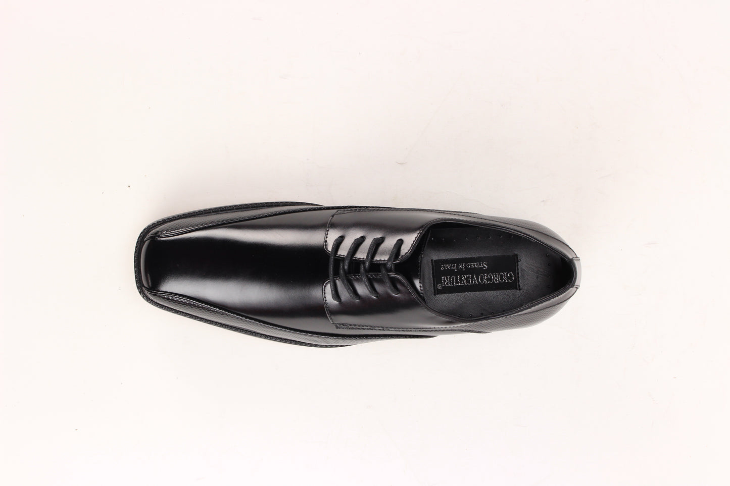 The Giorgio Venturi 7060 Black Leather Shoe features a bike toe, lace-up design, low heel, and embossed textured detailing on the sides and around the sole.