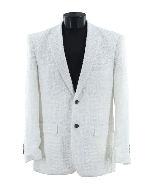 The Bassiri Blazer J1045-White by Bassiri features a textured white fabric, two buttons, notched lapels, and front flap pockets, shown on a black mannequin torso.
