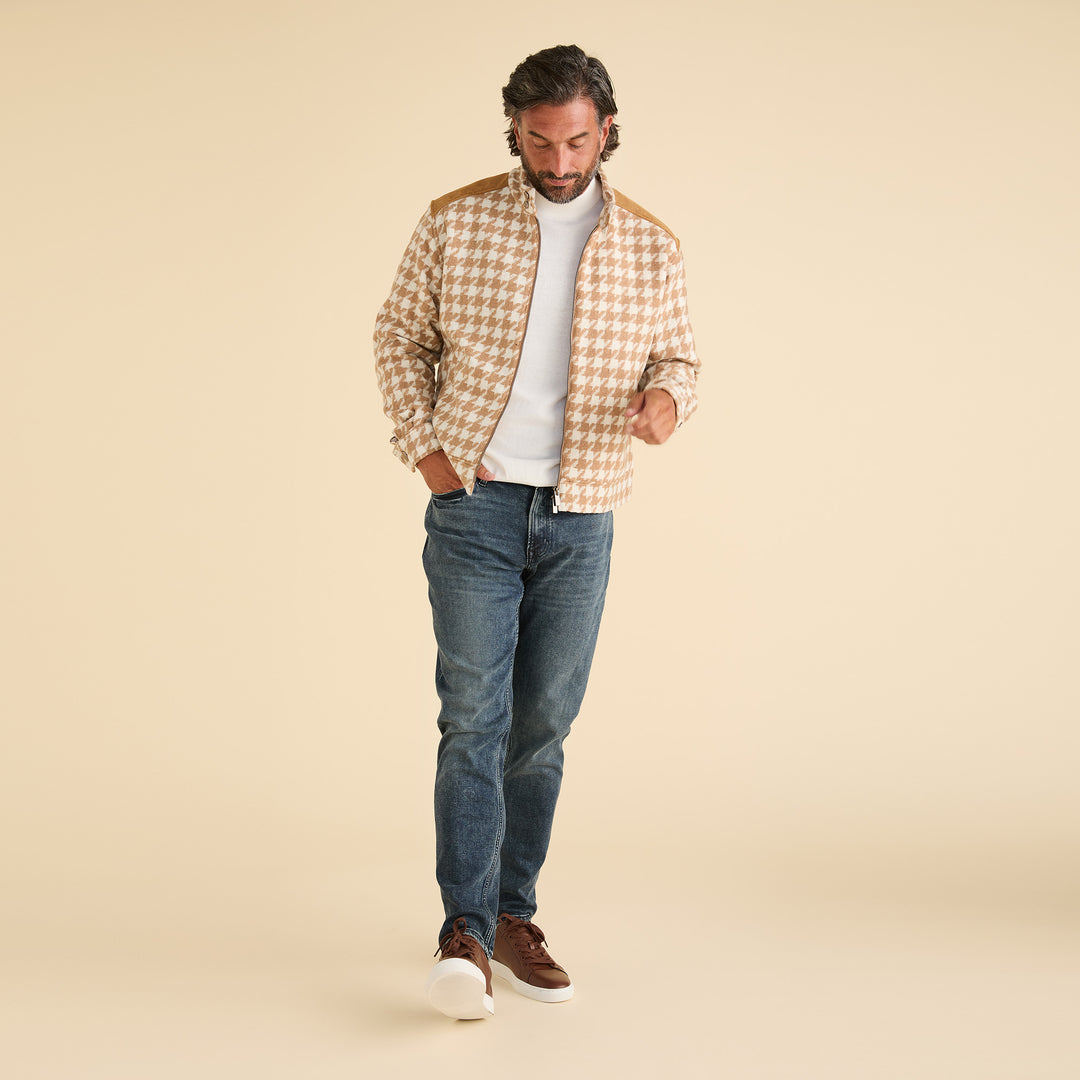 A man wearing the Inserch Wool Blend Houndstooth Full Zip Bomber Jacket (JS264B-09 Khaki), a white shirt, blue jeans, and brown shoes stands against a plain beige background.