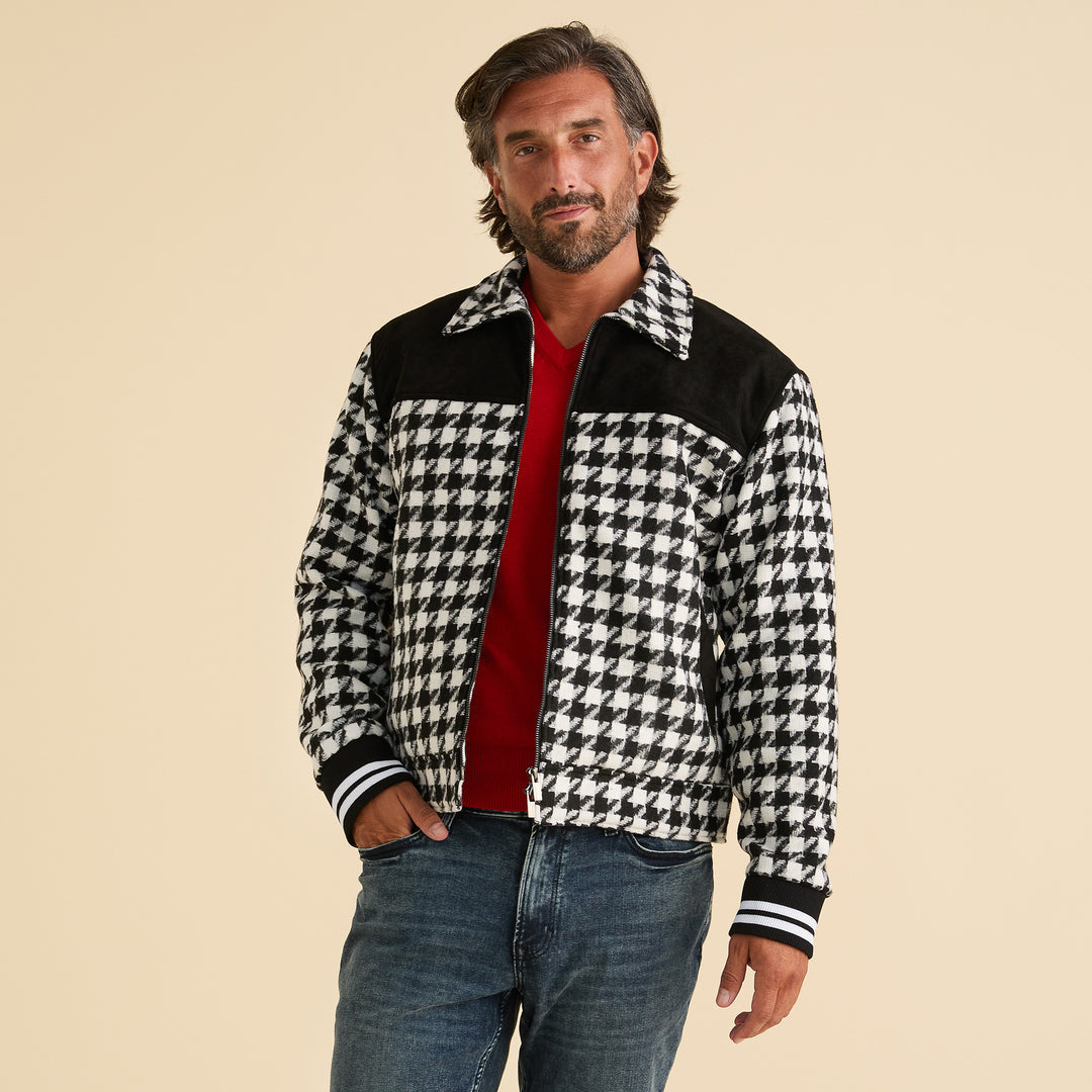 A man wears the Inserch Wool Blend Houndstooth Full Zip Bomber Jacket JS264-41 Black/White with black details, a red shirt, and blue jeans, standing against a plain beige background.