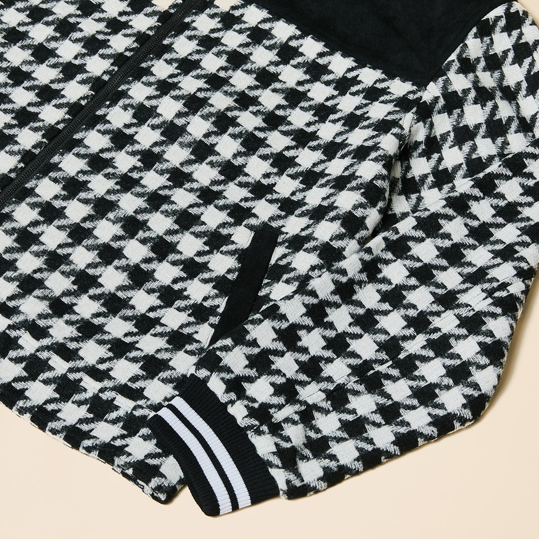 A man wears the Inserch Wool Blend Houndstooth Full Zip Bomber Jacket JS264-41 Black/White with black details, a red shirt, and blue jeans, standing against a plain beige background.