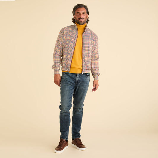 A man stands against a beige background, wearing a yellow turtleneck, blue jeans, brown sneakers, and the Inserch Micro Check Full Zip Jacket JS265-64 Mocha by Inserch.