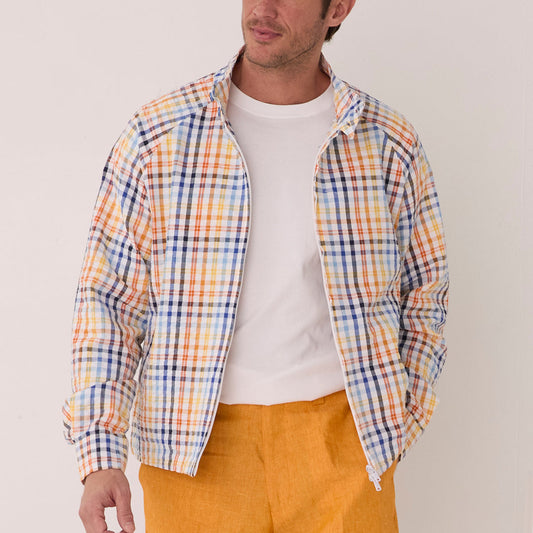 A man in an Inserch Seersucker Check Jacket JS271-00056 White Multi, featuring a classic collar, stylishly pairs it with a white t-shirt and bold orange pants against a plain white background.