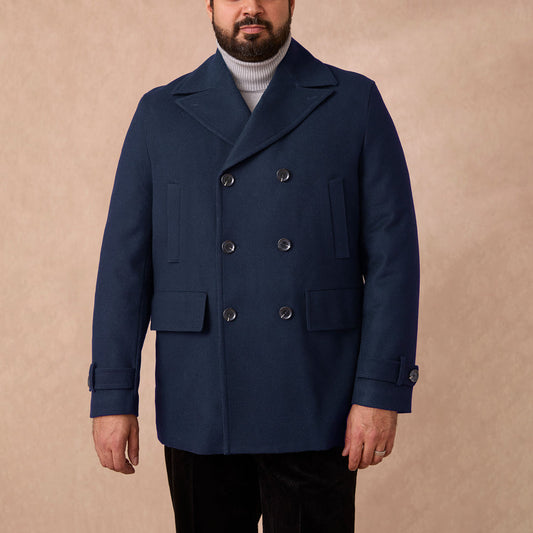 A man wearing an Inserch Wool Blend Peacoat JS558-00036 Ink double-breasted navy blue wool blend peacoat over a gray turtleneck sweater.