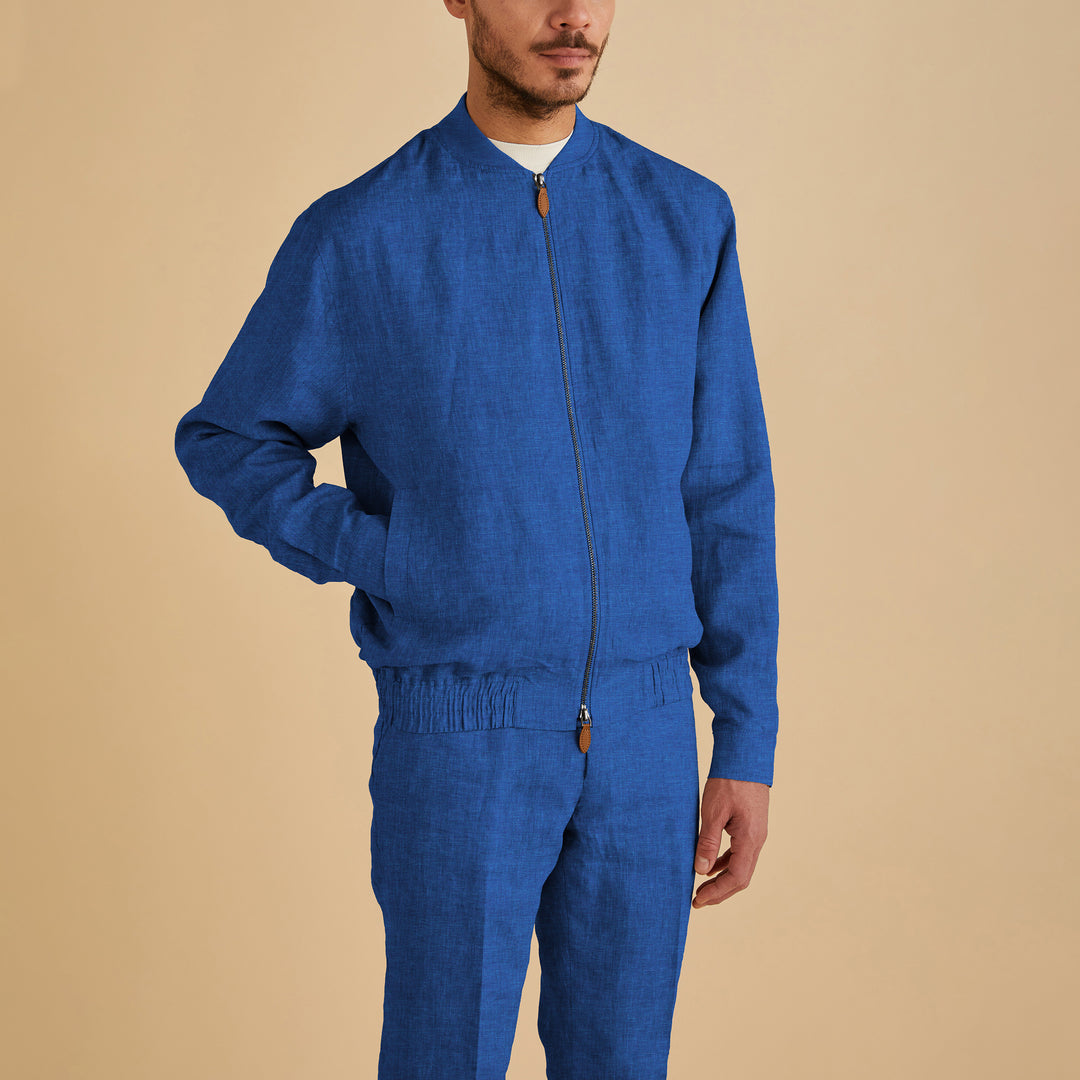 A man wears the Inserch Linen Bomber Jacket JS660-00181 in River Blue with matching pants, standing against a plain beige background.
