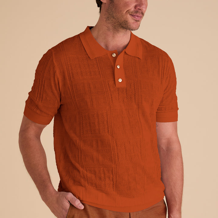 A man wears the Inserch SS Knit Polo KS001-00109 in burnt orange—a regular fit, textured knit polo with three buttons by Inserch—standing against a plain beige background.