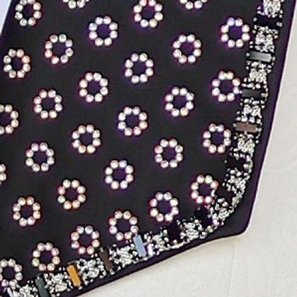 A man in an Insomnia MANZINI LEONARDO 2-Piece Fancy Rhinestone Cream Tuxedo Suit featuring a circle-patterned shawl collar and matching bow tie stands against a textured wall.