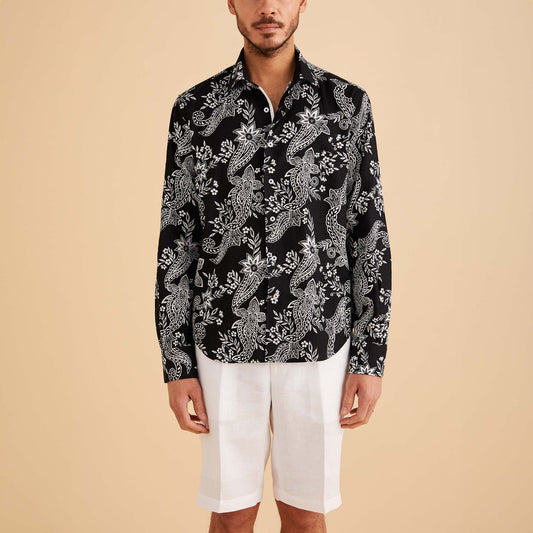 A man stands confidently against a beige background, dressed in the Inserch LS Paisley Print Linen Shirt (LS2915-00149) in white/black and white shorts.